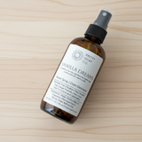 Bottle of 'Vanilla Dreams' room spray by Pretty Soap Co. on a wooden surface